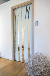 Drzwi przesuwne szklane – idealne do małych wnętrz. Salon w Warszawie